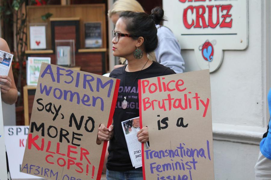 Women holding up signs; there to represent the organization A3FIRM, showing that police brutality is a Transnational Women’s Feminist issue. 