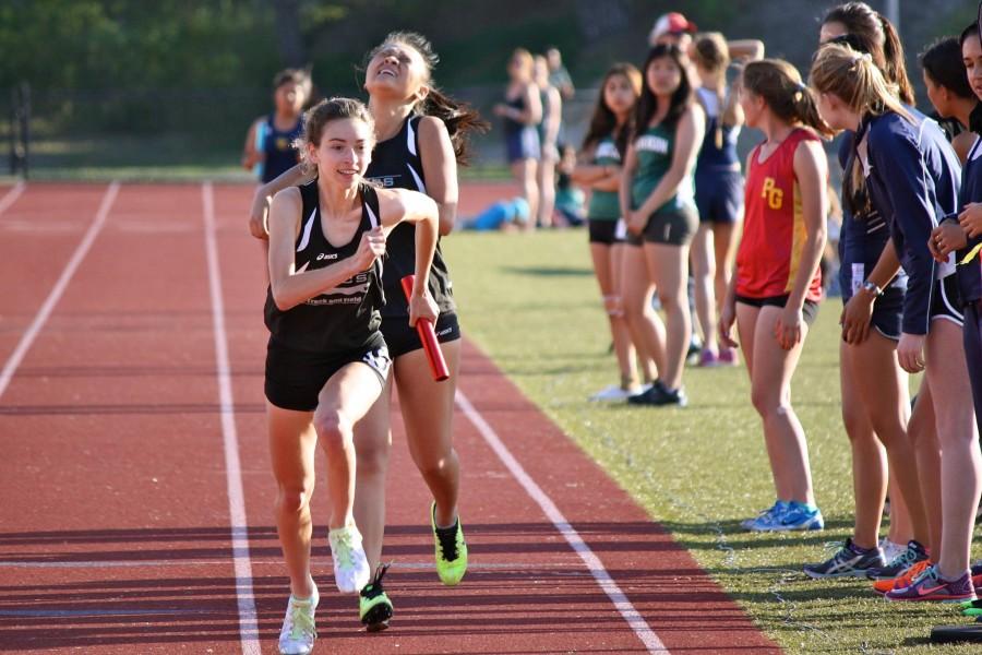 Photo Credit Eli Cushnir. Emily Antonino grasping the baton on the 4 x 400.